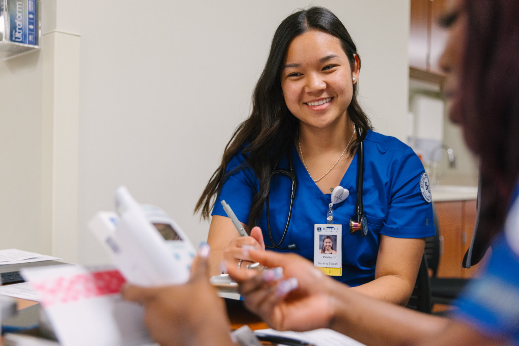 Bethel University nursing student smiling in blue scrubs